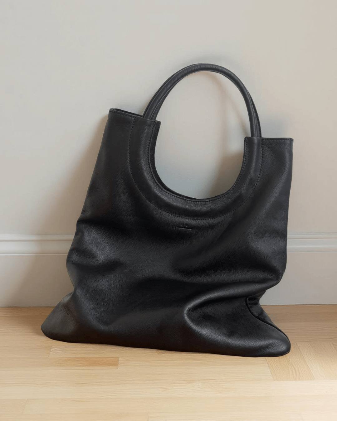 Mixed Emotions Reversible Tote in sleek black leather, stylish and spacious for everyday use.